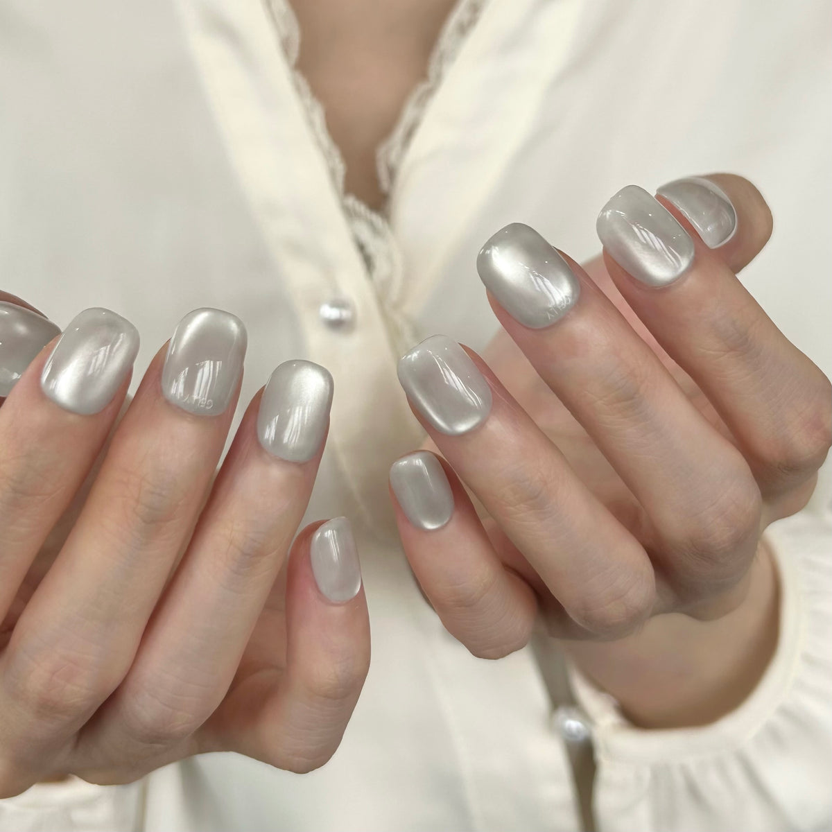 Close-up of hands with white cat eye GELLY press on nail, GELLY穿戴甲