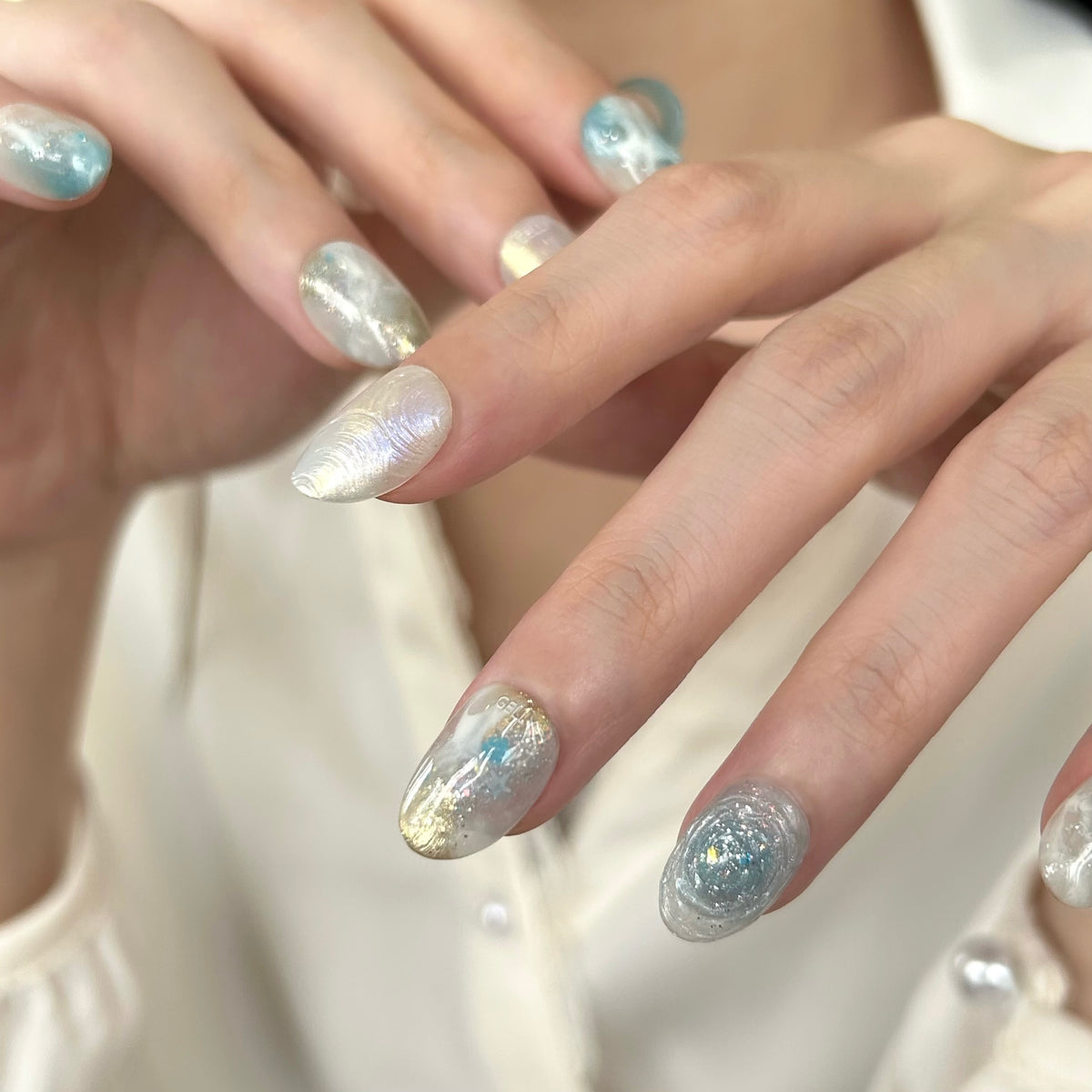 Close-up of hands with blue and white GELLY press on nails