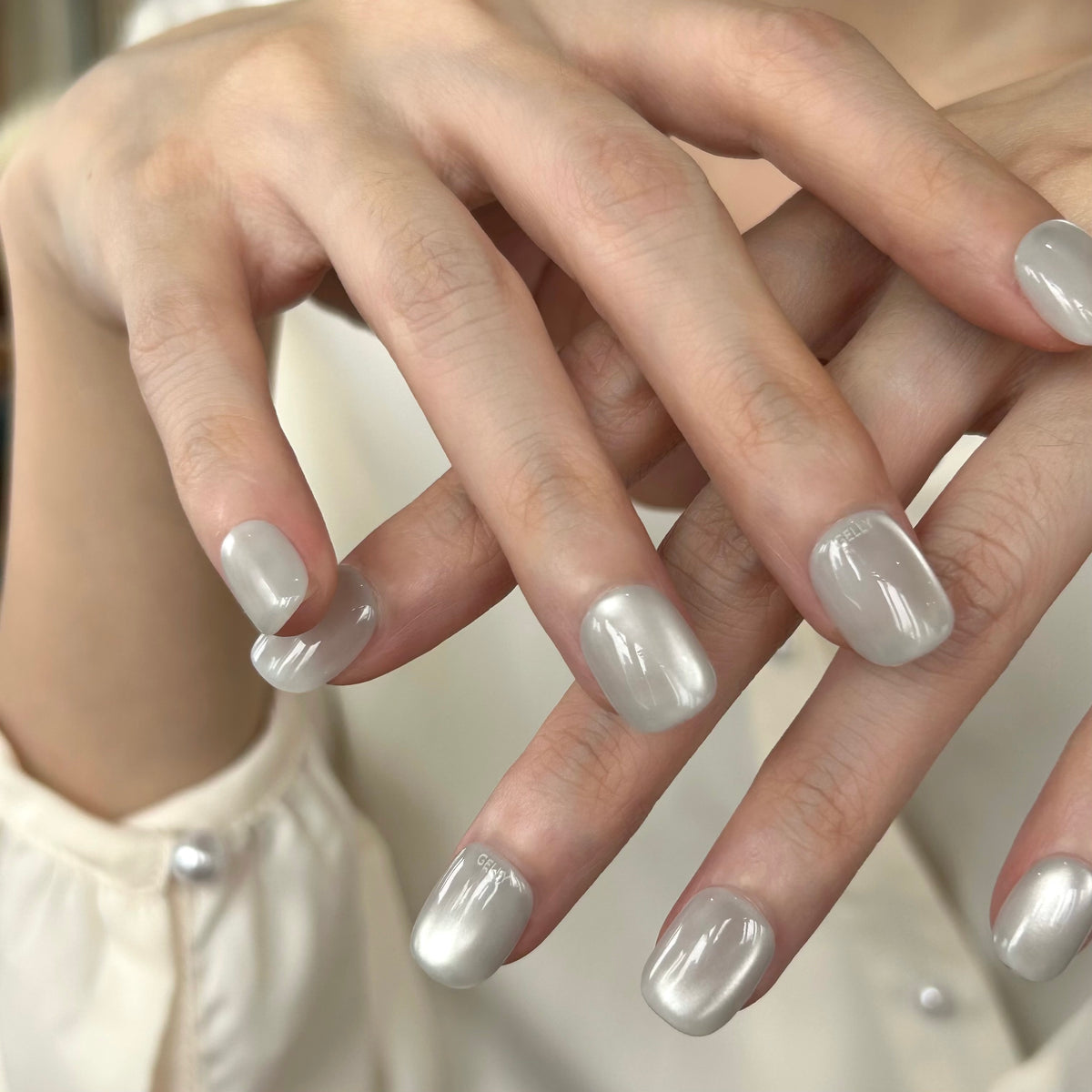 Close-up of hands with white cat eye GELLY press on nail, GELLY穿戴甲