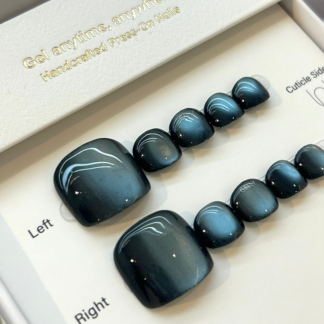 Set of black press-on nails in a box with branding text.