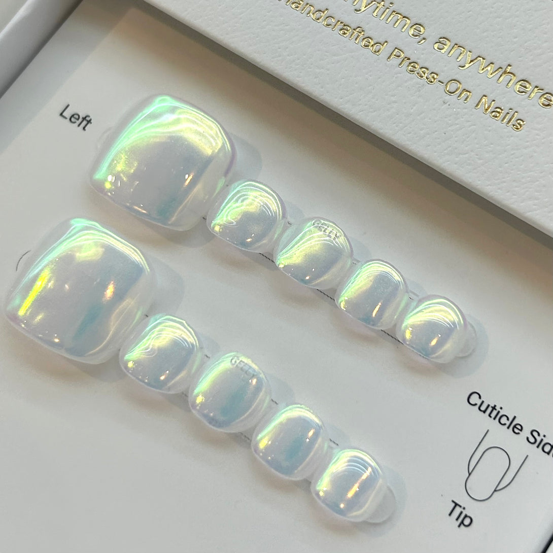 Set of press-on nails with a holographic finish on a branded box.