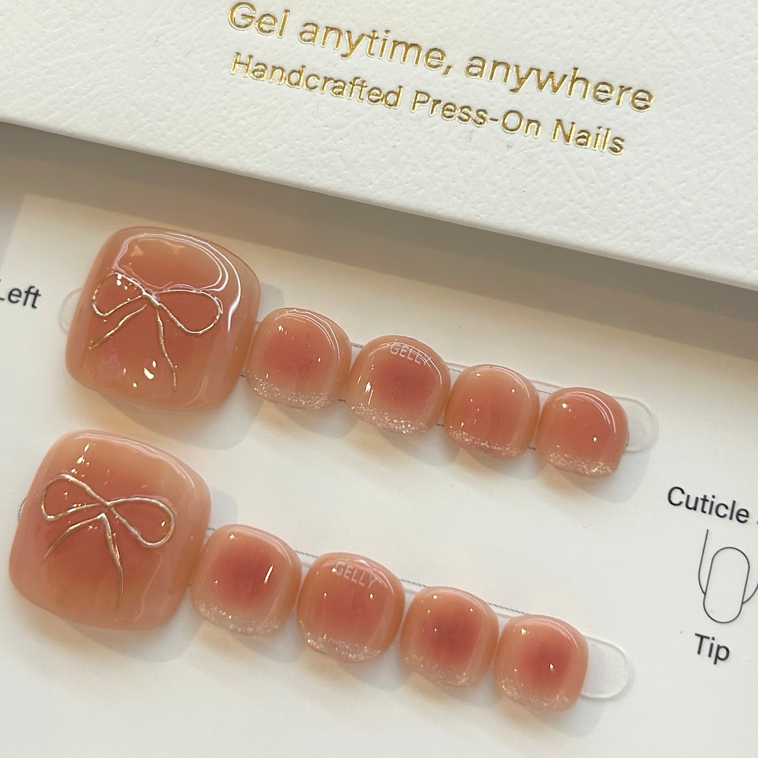 Set of press-on nails with a decorative bow design on a white background