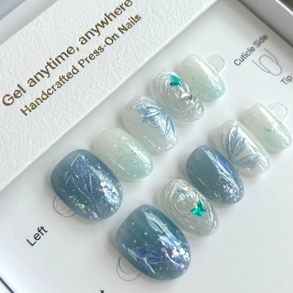 Set of press-on nails with a decorative design on a white tray