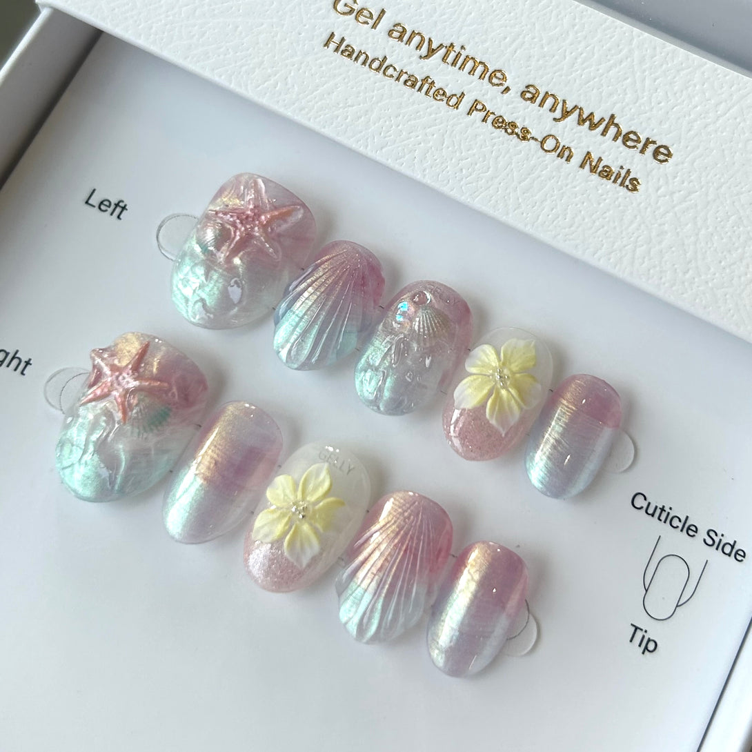 Set of press-on nails with shell and flower designs on a branded box.