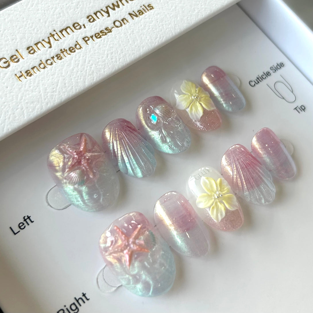 Set of press-on nails with floral designs on a branded tray.