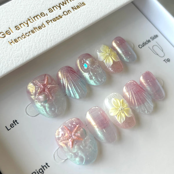 Set of press-on nails with floral designs on a branded tray.