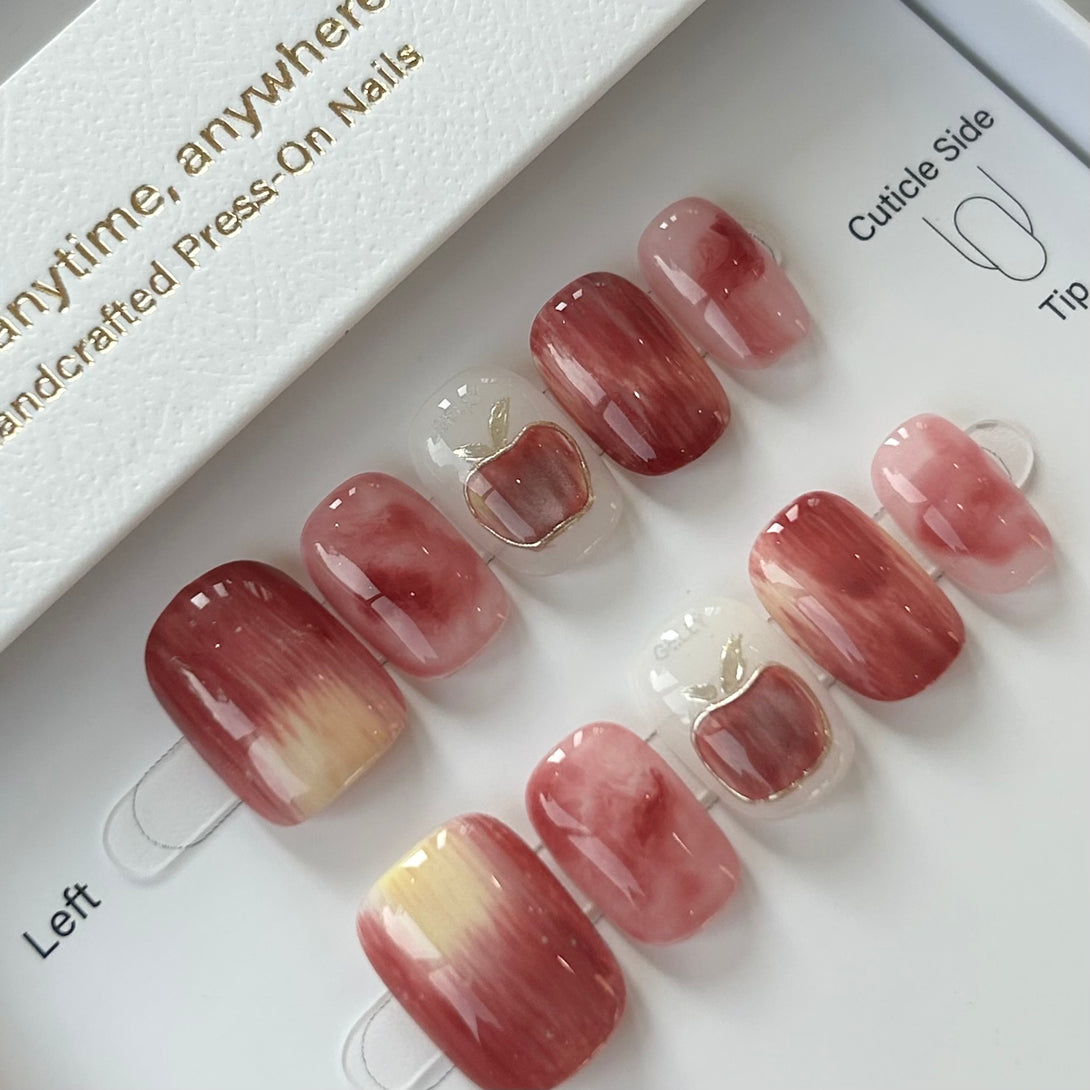 Set of press-on nails with a gradient design on a branded box.