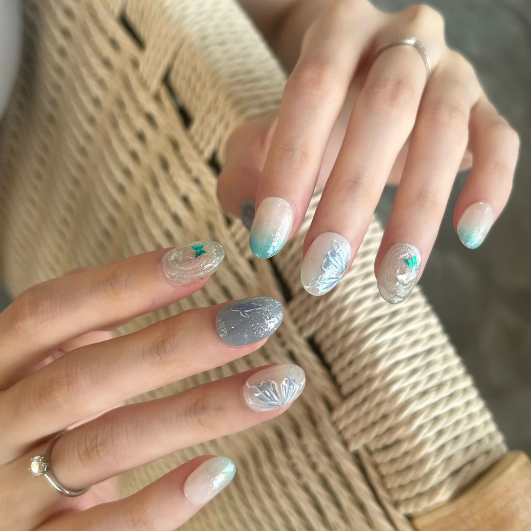 Close-up of hands with decorative nail art on a textured fabric background