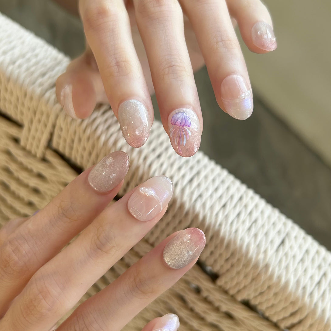Close-up of hands with decorative nail art on a textured surface