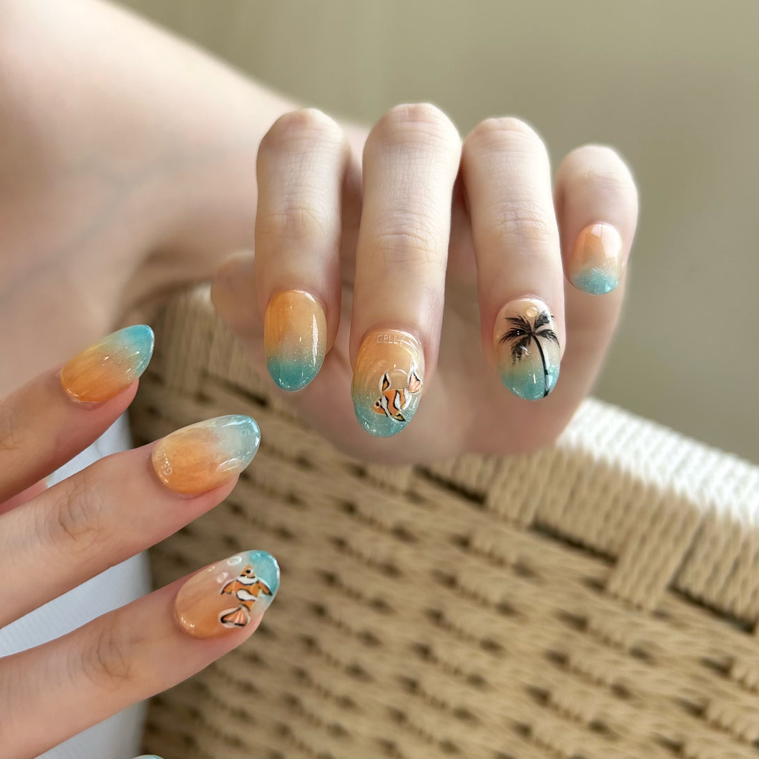 Hand with tropical-themed nail art featuring palm trees and fish on a neutral background